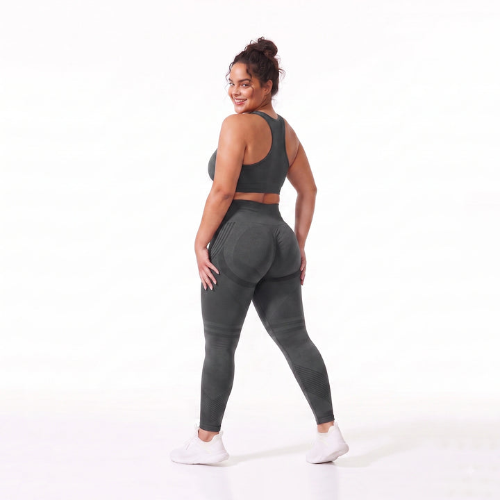 Mujer usando leggings de compresión gris oscuro, resaltando la textura acanalada que moldea y aporta firmeza visual a las piernas.